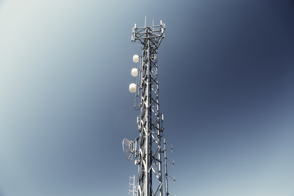 a signal tower in front of a blue sky