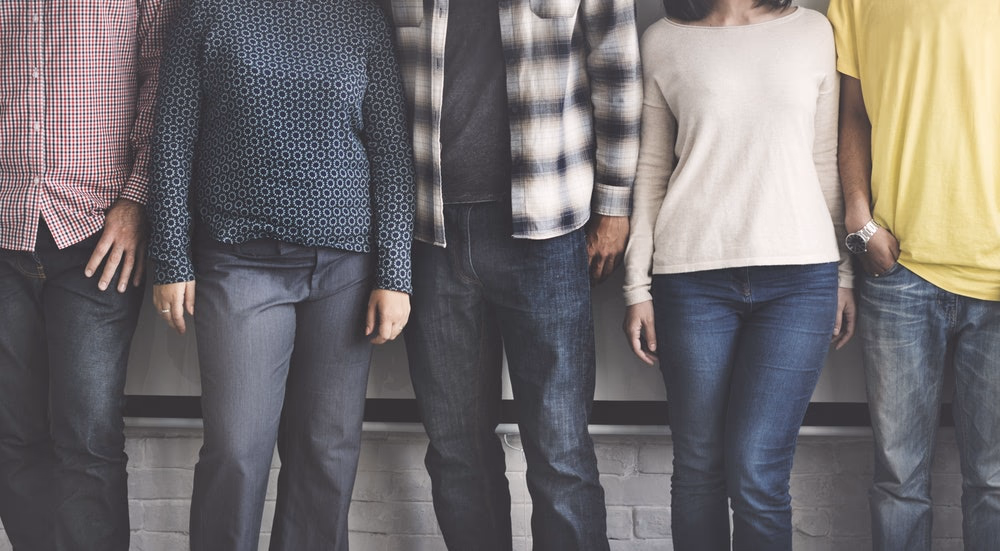 five people in various clothes standing next to each other