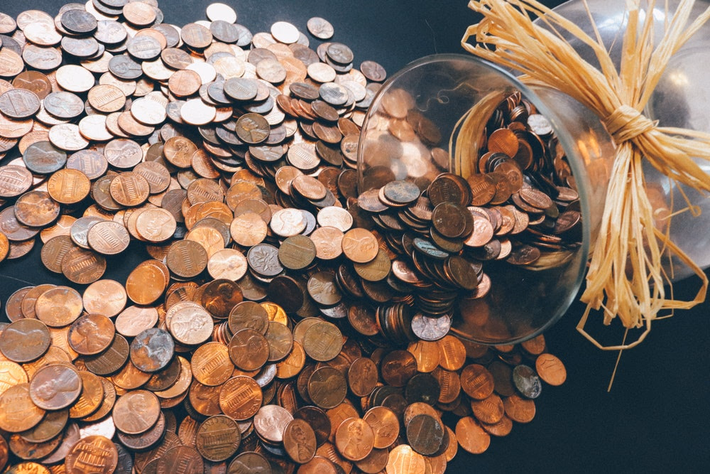 pile of coins spilled on a table from a jar
