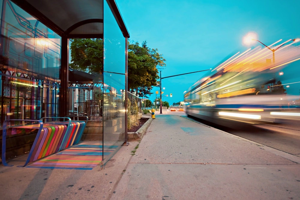 widok na nowoczesny przystanek autobusowy, z rozmytym autobusem w ruchu po prawej stronie